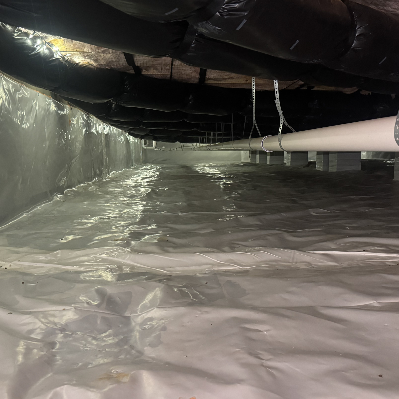 14 image Detailed view of a sealed crawl space showing vapor barrier material and advanced moisture management system components.